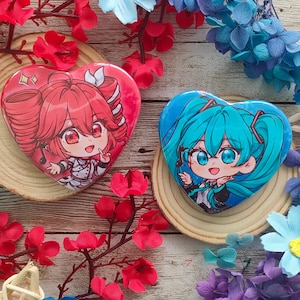 May include: Two heart-shaped anime character badges, one red and one blue, rest on wooden coasters. The red badge features a character with red hair, while the blue badge has a character with blue hair. The scene is decorated with red, blue, and purple flowers.