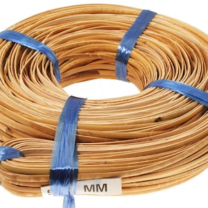 May include: A roll of natural-colored, flat, woven rattan cane, approximately 5 mm wide, wrapped with blue tape. The cane is used for crafting and weaving.