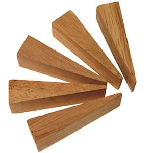 May include: Five wooden shims, also known as wood wedges, are arranged in a fan shape. The shims are made of light brown wood and are all the same size and shape.