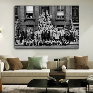 May include: Black and white photograph of a large group of people standing in front of a building. The people are all dressed in formal attire and appear to be smiling. The building is a brick building with a large window on the second floor.