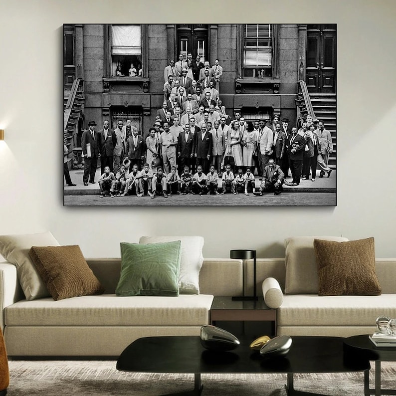 May include: Black and white photograph of a large group of people standing in front of a building. The people are all dressed in formal attire and appear to be smiling. The building is a brick building with a large window on the second floor.