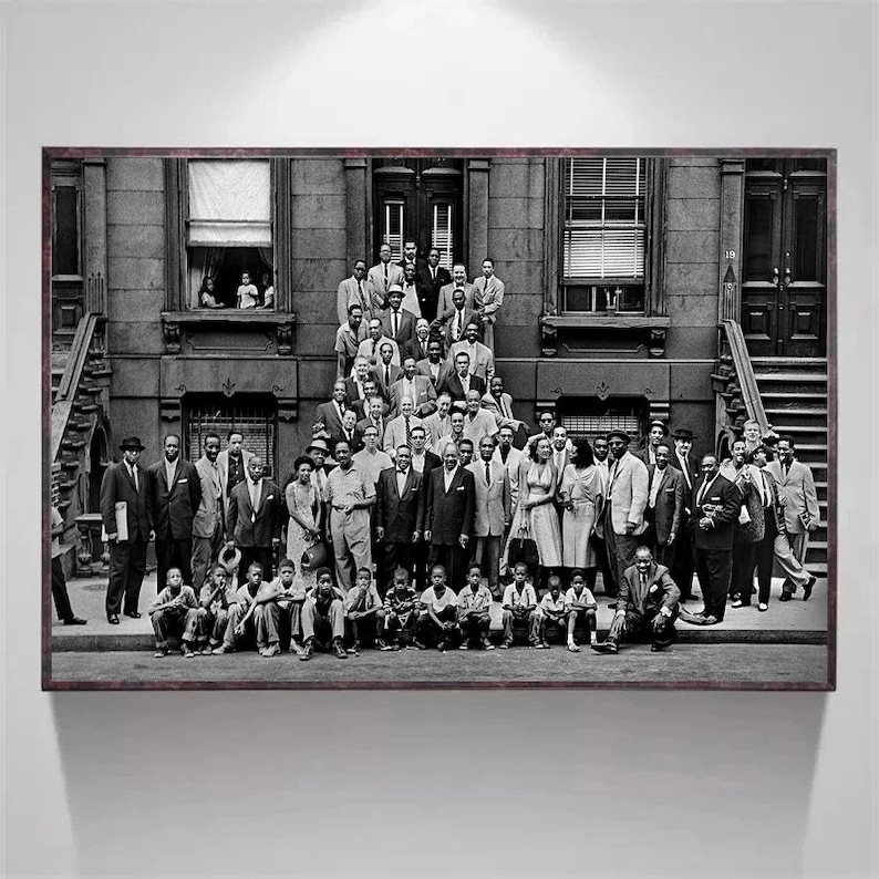 May include: A black and white photograph of a large group of people standing in front of a building. The people are all dressed in formal attire and appear to be celebrating an event. The building has a large entrance with a set of stairs leading up to it.