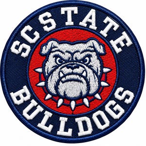 May include: A circular embroidered patch featuring a white bulldog head with a spiked collar centered on a red background. The outer navy blue border contains the white text SC STATE BULLDOGS in a bold, capitalized, sans-serif font.