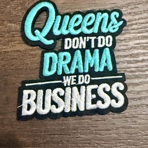 May include: Embroidered patch with the text "Queens Don't Do Drama We Do Business" in teal and white lettering on a black background. The patch is rectangular with rounded edges.