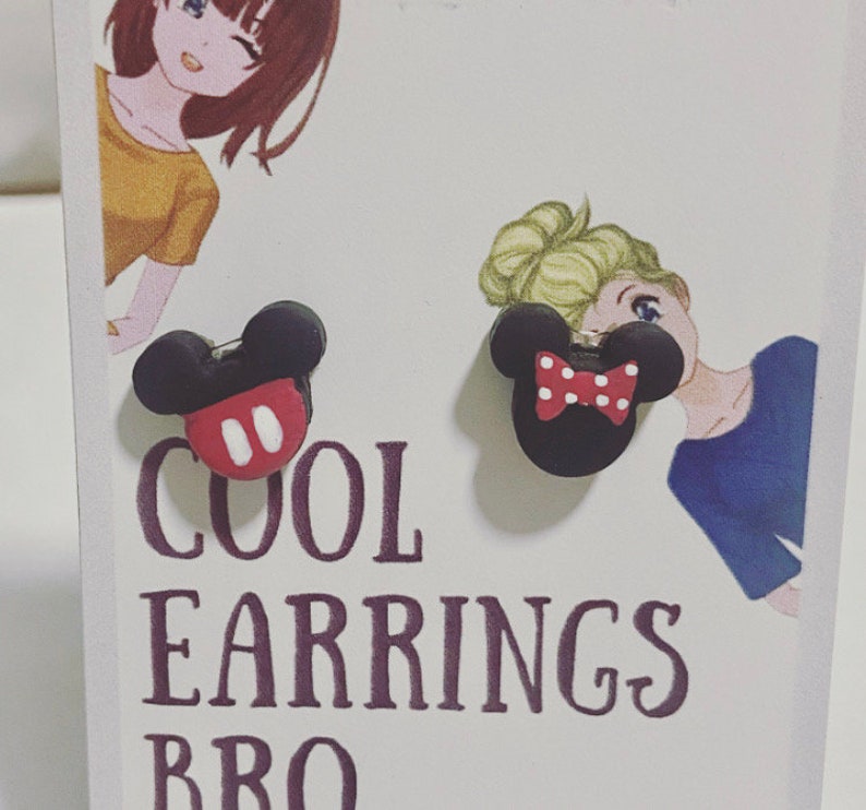 May include: A pair of black and red Mickey Mouse and Minnie Mouse earrings. One earring has a red bow with white polka dots. The other earring has a red face with two white circles. The text "COOL EARRINGS BRO" is printed below the earrings.