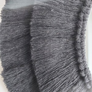 Puede incluir: Borde de flecos negro con un borde trenzado. Los flecos est&aacute;n hechos de un material suave y texturizado.