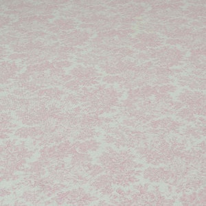 May include: A close-up of a pink and white fabric with a delicate floral pattern. The fabric has a subtle sheen and a soft texture.