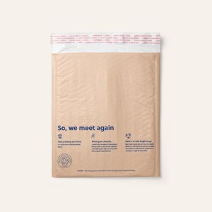 May include: A tan-coloured, rectangular padded shipping mailer made from recycled plastic. The front features the text 'So, we meet again' in blue, along with three icons and descriptive text about its recycled nature and instructions for reuse.