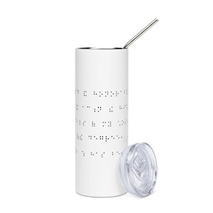May include: White stainless steel tumbler with a black braille pattern and a clear lid. The tumbler has a silver straw.