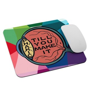 May include: A colorful mouse pad with a geometric design. The center of the pad features a stylized eye with the text "TILL YOU MAKE IT" and "PHAKIC" written on the side.
