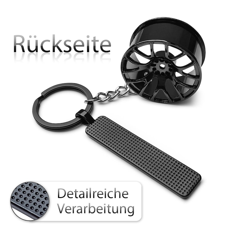 May include: Black metal car wheel keychain with a detailed textured design. The keychain features a ring and a chain.