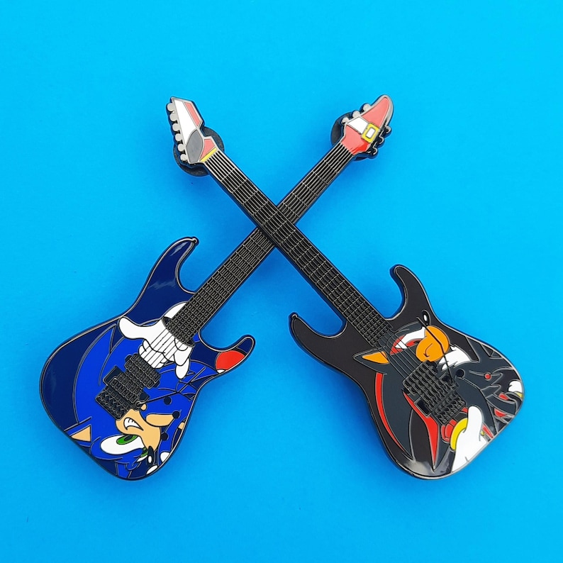 Enamel pin badges based on the ESP Sonic-II and Shadow-II guitars, shown here with the necks of the guitars crossed for display.