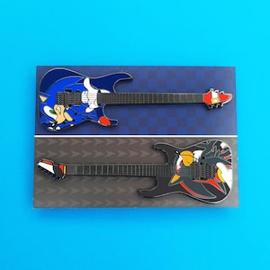 Enamel pin badges based on the ESP Sonic-II and Shadow-II guitars, shown here on the backing card if you purchase them together.