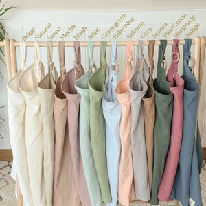 Puede incluir: Un conjunto de 15 bolsas de almacenamiento colgantes de tela en varios colores, incluyendo beige, natural, piedra, moca, rubor, menta, verde hierba, azul beb&eacute;, salm&oacute;n, gris, marr&oacute;n, verde pino, burdeos e &iacute;ndigo. Cada bolsa tiene un anillo de madera en la parte superior para colgar.