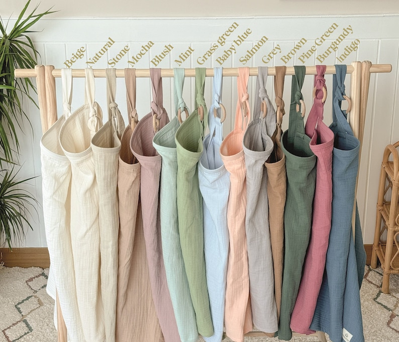 Puede incluir: Un conjunto de 15 bolsas de almacenamiento colgantes de tela en varios colores, incluyendo beige, natural, piedra, moca, rubor, menta, verde hierba, azul beb&eacute;, salm&oacute;n, gris, marr&oacute;n, verde pino, burdeos e &iacute;ndigo. Cada bolsa tiene un anillo de madera en la parte superior para colgar.