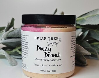May include: A jar of Briar Tree Soapery's "Boozy Brunch" whipped foaming sugar scrub. The label lists peach, apricot, vanilla, and rum as ingredients. The jar is 8 oz / 226g and has a black lid.