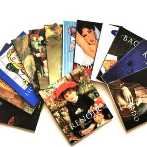 May include: A collection of art books fanned out on a white surface. The book covers feature various famous paintings and artists, including Renoir, Leonardo, and Matisse. The books are from the Taschen publishing house.