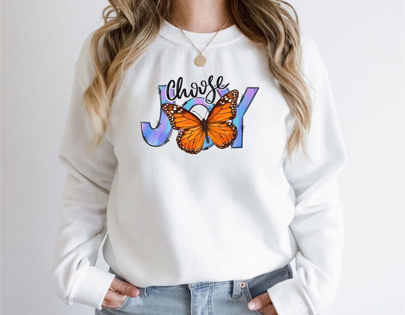 May include: White sweatshirt with a colorful butterfly graphic and the text "Choose Joy" printed on the front.