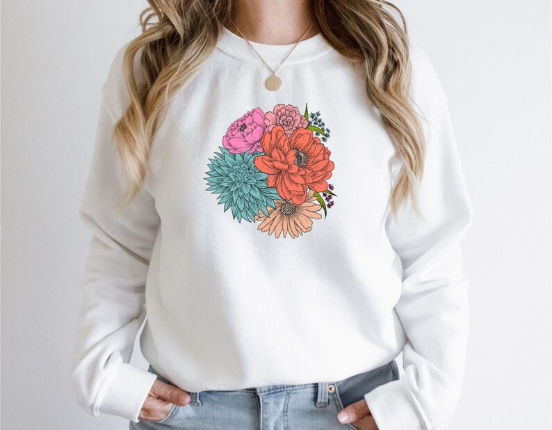 Pu&ograve; includere: Felpa bianca con stampa floreale colorata con fiori rosa, rossi, arancioni, blu e verdi.