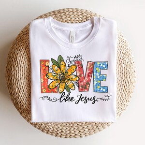 May include: White t-shirt with a floral design that spells out "LOVE like Jesus".