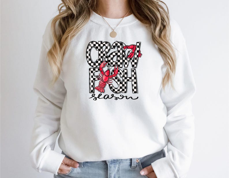 May include: White sweatshirt with a black and white checkered design that says "Crawfish Season" with a red crawfish illustration.