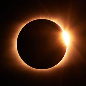May include: A total solar eclipse, with the sun's corona visible as a bright ring around the moon's silhouette.
