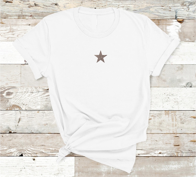 May include: White t-shirt with a brown star on the front.