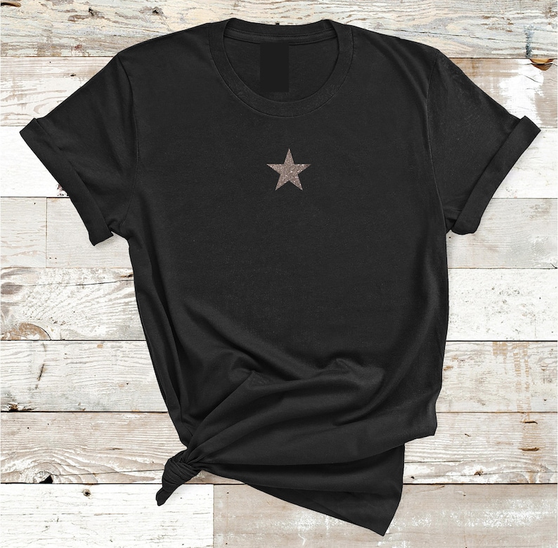 May include: A black t-shirt with a small, glittery gold star on the front.