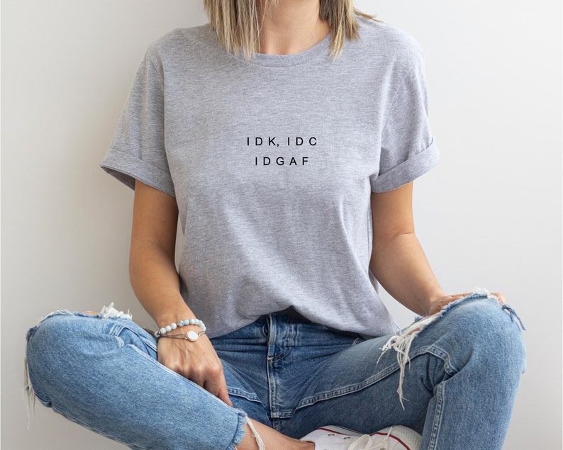 May include: A gray t-shirt with the text "IDK, IDC IDGAF" printed on the front.