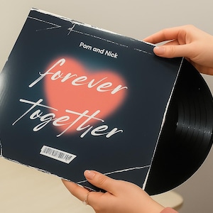 May include: A vinyl record in a sleeve with the words "forever together" in white script over a red heart. The record sleeve is dark blue with the names "Pom and Nick" at the top.
