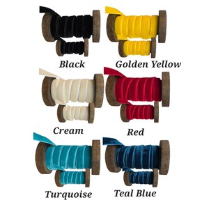 May include: Six pairs of wooden spools wrapped with velvet ribbon in black, golden yellow, cream, red, turquoise, and teal blue. Each set includes one large and one small spool, displaying the colour names in black text below each pair.