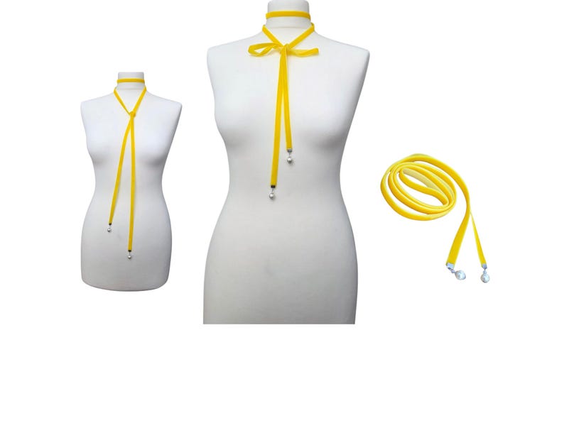Pu&ograve; includere: Collana girocollo in velluto giallo con chiusura a fiocco e estremit&agrave; pendenti. La collana &egrave; esposta su un manichino, con una collana arrotolata separata. Le estremit&agrave; hanno piccoli accenti color argento.