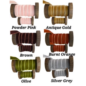 May include: Six pairs of velvet ribbon spools in powder pink, antique gold, brown, burnt orange, olive, and silver grey. Each colour features a large and a small wooden spool wrapped with matching velvet ribbon, labelled with its respective colour name.