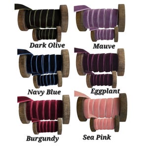 May include: Six pairs of velvet ribbon spools in dark olive, mauve, navy blue, eggplant, burgundy, and sea pink. Each set includes one large and one small wooden spool wrapped with solid coloured velvet ribbon, labelled with the colour name below.