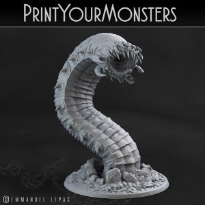 May include: A 3D printed grey model of a monstrous worm with a gaping maw and sharp teeth. The worm is posed in a curled position, with its head raised and its body resting on a rocky base.