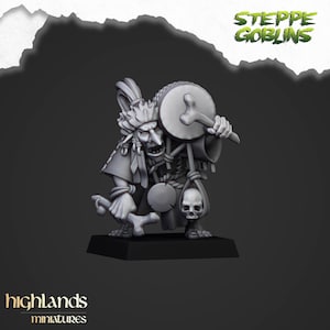 May include: A gray miniature figurine of a Steppe Goblin, holding a drum and a skull. The figurine is on a black base, with the words "Steppe Goblins" and "highlands miniatures" visible.