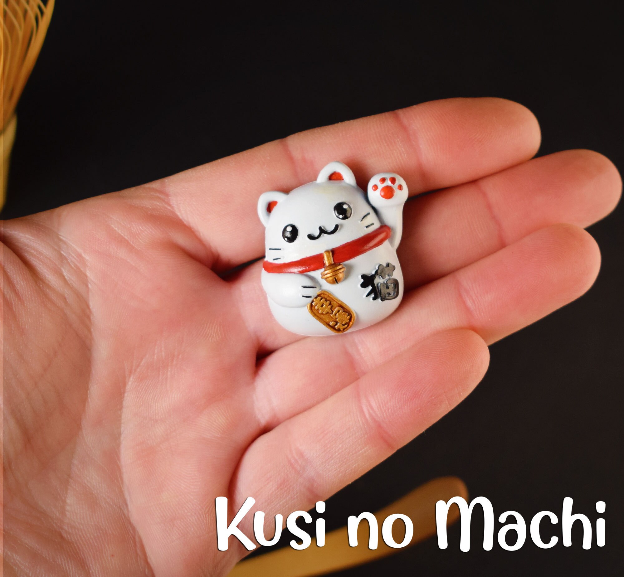 Pendentif porte-bonheur japonais illustrant le maneki neko