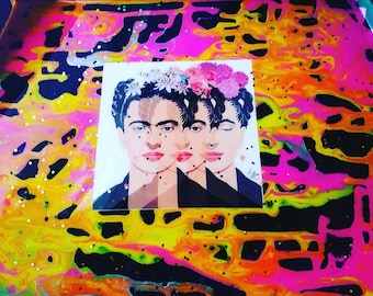 May include: A colorful abstract background with a sticker of a portrait of Frida Kahlo. The portrait shows Frida Kahlo with a flower crown and a black dress. The background is a mix of pink, yellow, orange, and black.