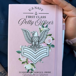 May include: A light pink notebook featuring a U.S. Navy First Class Petty Officer insignia, a silver eagle, and chevron rank. The cover is decorated with pink and white roses, the text "LEADERSHIP, SERVICE, PRIDE," and the name "AS1 (AW) Ortega."