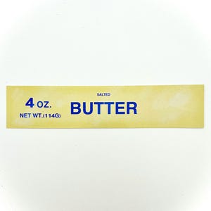 May include: A yellow label with blue text that reads "SALTED BUTTER 4 oz. NET WT. (114G)"