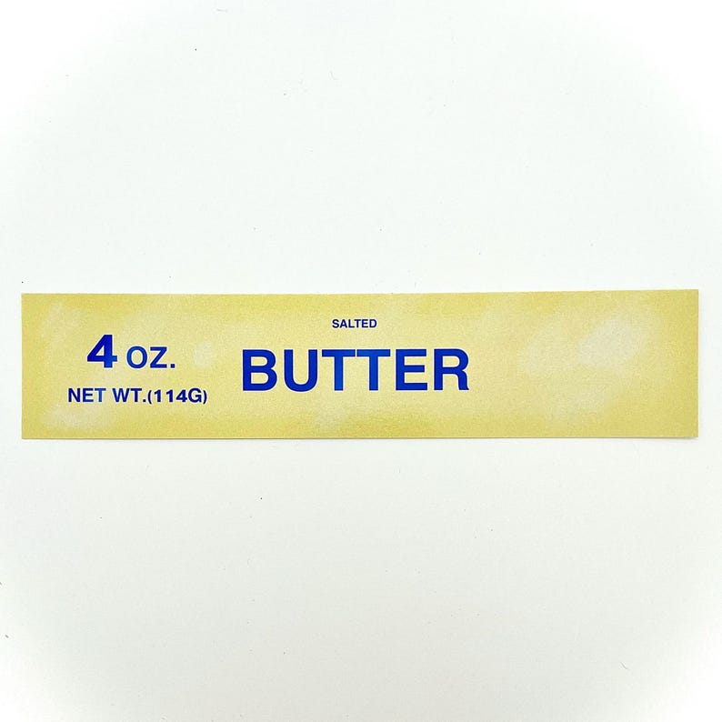 May include: A yellow label with blue text that reads "SALTED BUTTER 4 oz. NET WT. (114G)"