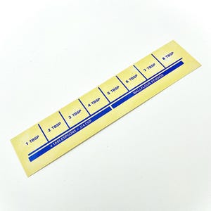 May include: A yellow measuring tool with blue markings for tablespoons. The tool is labeled "4 tablespoons = 3/4 cup" and "Wallflour Studios".