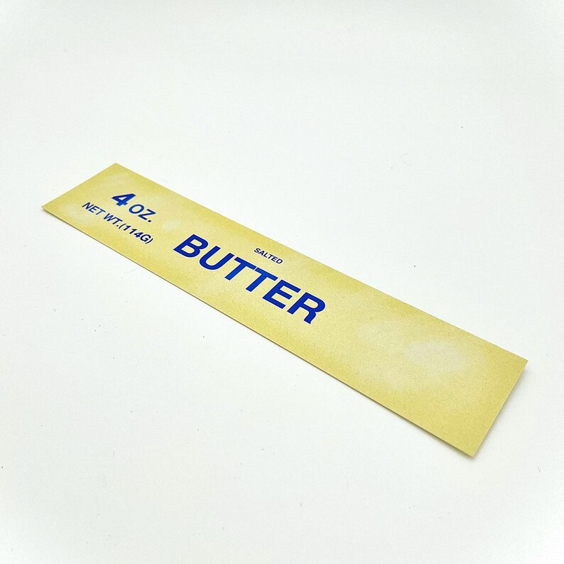 May include: A yellow label with blue text that reads "4 oz. NET WT. (114G) SALTED BUTTER".