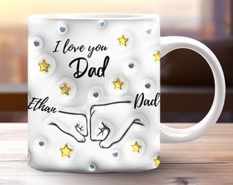 Könnte beinhalten: Weiße Keramiktasse mit einer schwarz-weißen Illustration von zwei Händen, die sich die Faust geben. Die Tasse hat einen blauen Henkel und ist mit goldenen Sternen und blauen Herzen verziert. Der Text "I love you Dad" ist in Schwarz auf der Tasse geschrieben. Die Namen "Ethan" und "Dad" sind unter den Händen geschrieben.