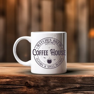 May include: White ceramic coffee mug with a black and white graphic design that says "Witches Brew Coffee House - Elixirs & Spell Blends".