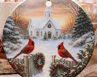 Peut inclure: Ornement de Noël rond représentant une scène hivernale avec une église blanche, des arbres enneigés et deux cardinaux rouges sur une clôture en bois. L'ornement a une ficelle dorée pour l'accrocher.