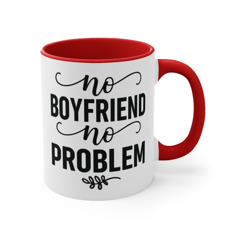 May include: White ceramic mug with a red interior and handle. The mug features the text "no BOYFRIEND no PROBLEM" in black script and block letters. A small floral design is at the bottom of the text.