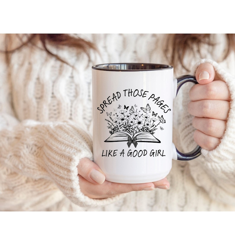 Puede incluir: Taza de cer&aacute;mica blanca con interior y asa negros. La taza presenta el texto "SPREAD THOSE PAGES LIKE A GOOD GIRL" con un dise&ntilde;o floral y de mariposas. Un regalo perfecto para los amantes de los libros.