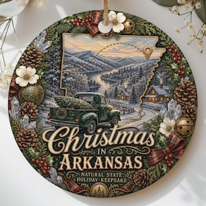 May include: A round Christmas ornament featuring a green vintage truck carrying a tree, a snowy landscape, and the text "Christmas in Arkansas Natural State Holiday Keepsake." The design is framed by pine branches, pinecones, berries, and white flowers.