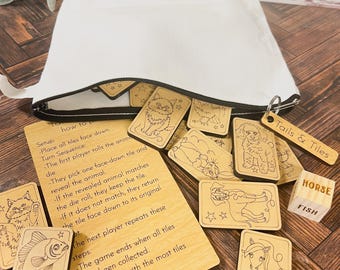 May include: A set of wooden tiles with illustrations of animals, a dice, and instructions for a game called "Tails & Tiles". The game involves matching the animal on the tile to the number rolled on the dice.